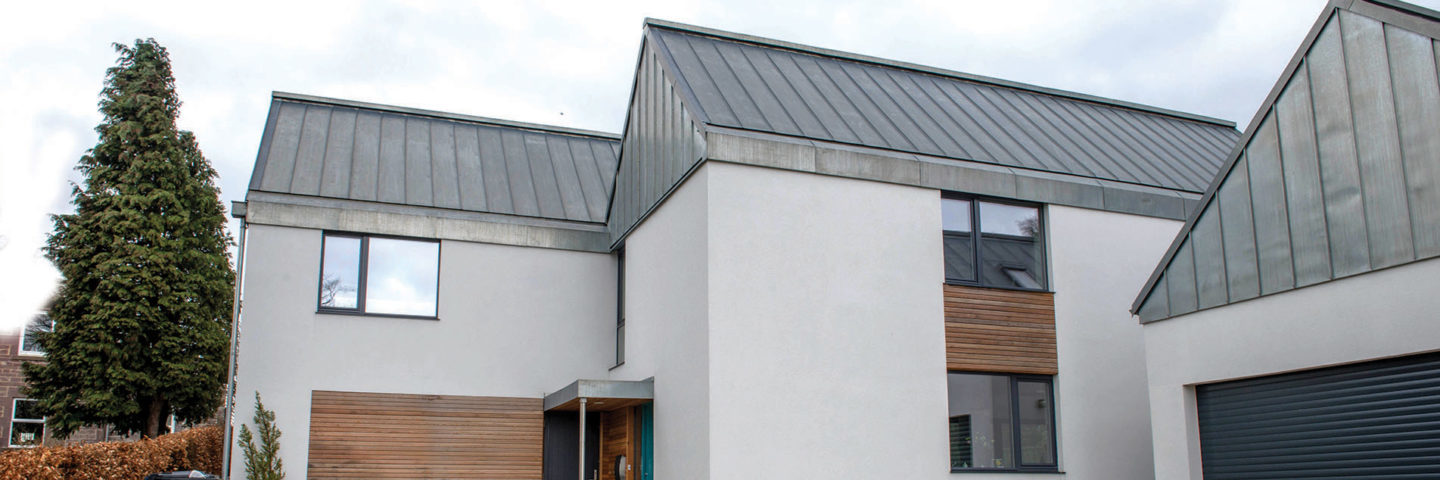 white-contemporary-house-with-steel-grey-roof-and-tall-tree-on-the-left-and-garage-block-on-the-right