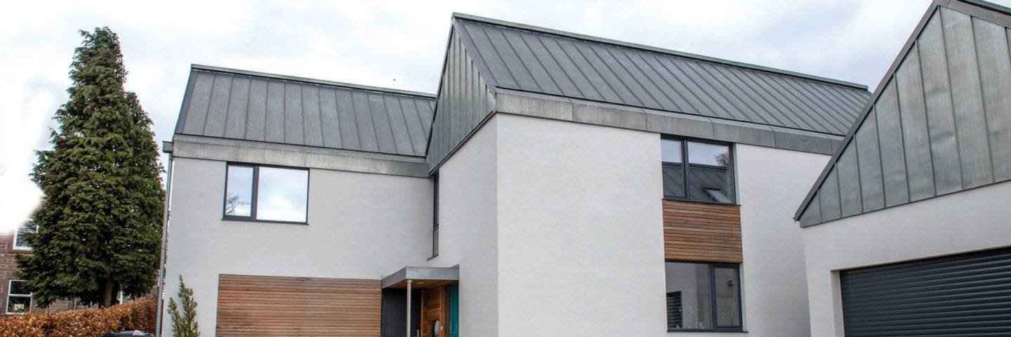 white-contemporary-house-with-steel-grey-roof-and-tall-tree-on-the-left-and-garage-block-on-the-right