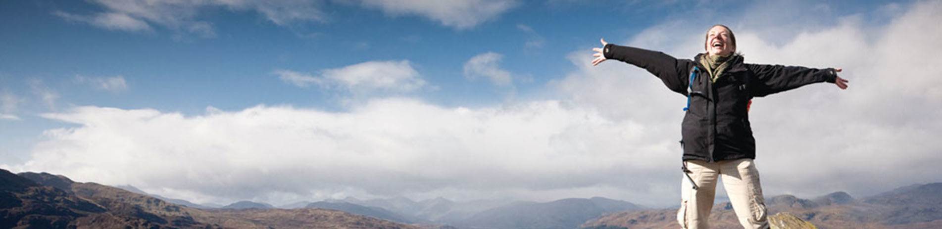 happy-woman-with-arms-spread-wide-on-summit-of-ben-ann-in-the-trossachs