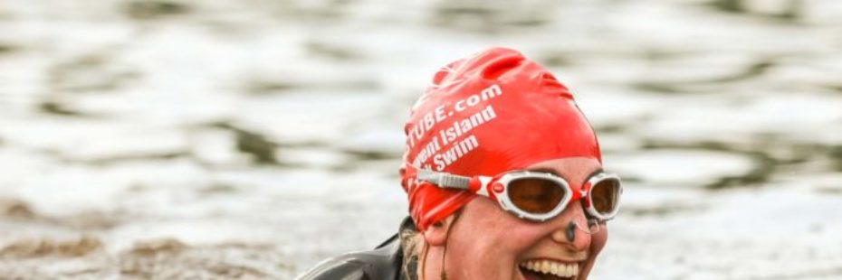 woman-swimmer-with-red-cap-googles-and-nose-clip-smiling-widely-while-swimming-in-loch