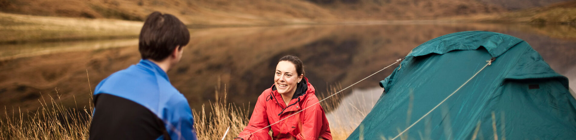 couple-cooking-next-to-tent-at-the-edge-of-lochan