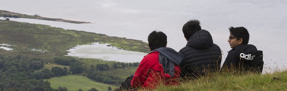 group-of-three-boys-on-hill-slope-looking-down-on-loch-lomond