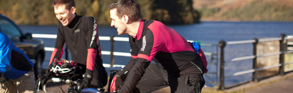 two-cyclists-chatting-to-each-other-while-on-bikes-on-pier-at-loch-katrine