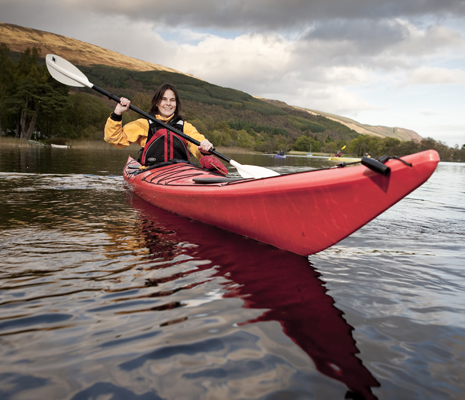 smiling-woman-peddling-red-kayak-on-loch-lomond