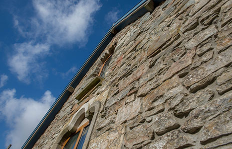 close-up-of-stone-building-with-arched-windows-and-blue-skies-above