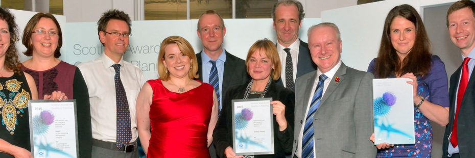 national-park-staff-proudly-holding-their-scottish-awards-for-quality-in-planning-certificates-and-smiling