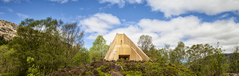 an-ceann-mor-wooden-structure-scenic-art-installation-among-trees-with-blue-sky-and-clouds-above