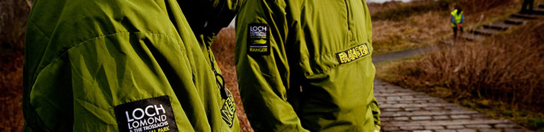 close-up-on-two-rangers-green-jackets-with-national-park-logo-and-ranger-word-visible-on-their-sleeve-and-chest