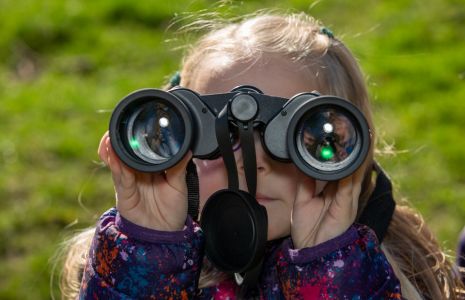 Young child looking through binoculars