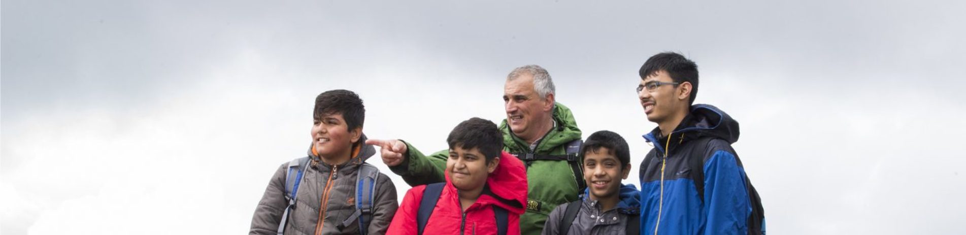 national-park-ranger-with-group-of-boys-pointing-into-distance