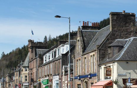 main-street-in-callander-old-stone-buildings-with-forest-canopy-visible-behind