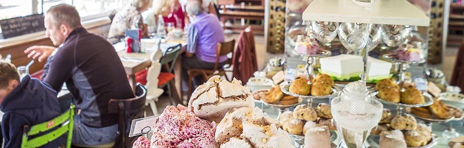 mhor-eighty-four-restaurant-interior-meringues-visible-on-plate-and-other-sweets-with-people-siting-down-at-tables-on-left