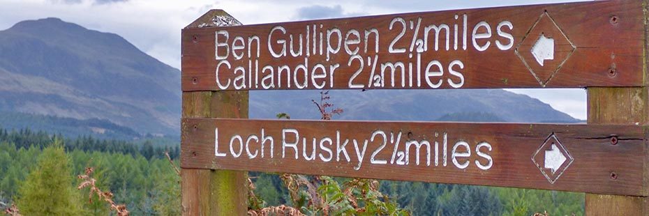 distance-wooden-post-reading-ben-gullipen-two-and-a-half-miles-callander-two-and-a-half-miles-loch-rusky-two-and-a-half-miles-hills-and-forests-in-the-distance