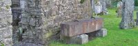 metal-coffin-exposed-on-stones-in-ancient-graveyard-next-to-church-ruins