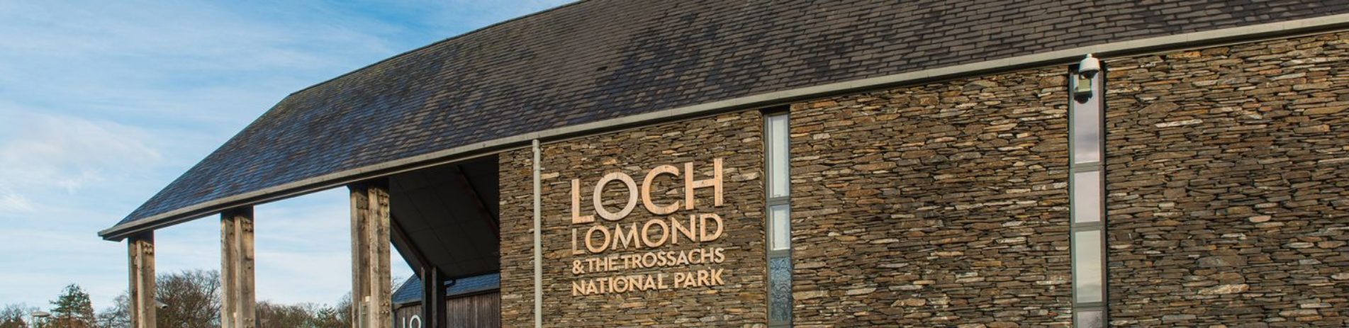 loch-lomond-and-trossachs-national-park-authority-headquarters-building-made-of-stone-and-with-slate-roof-logo-prominent-next-to-entrance