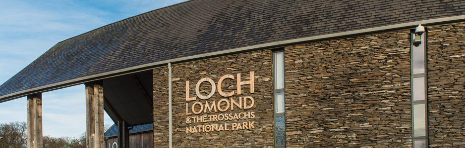 loch-lomond-and-trossachs-national-park-authority-headquarters-building-made-of-stone-and-with-slate-roof-logo-prominent-next-to-entrance