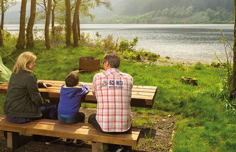 family-at-picnic-table-next to tent-and-loch