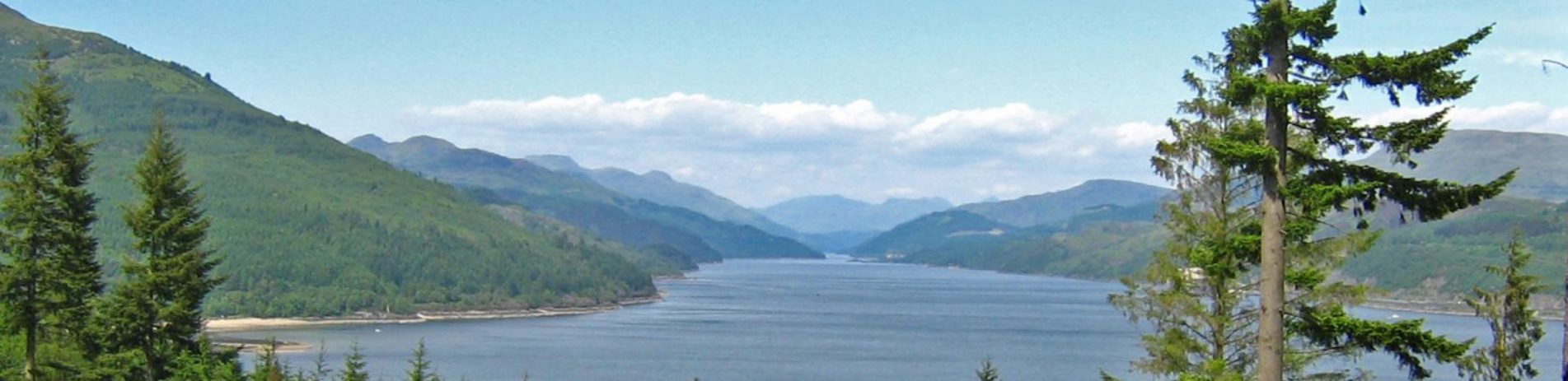 panoramic-loch-and-tree-covered-mountains