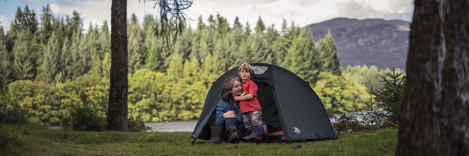 woman-holding-young-boy-at-tent-entrance-at-three-lochs-forest-drive