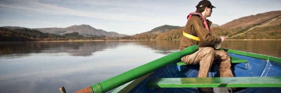 boat-fisherman-on-loch-with-mountain-background