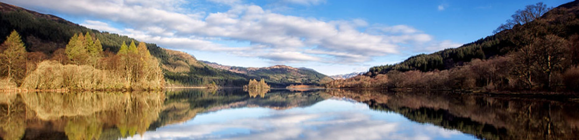 loch-forest-mountains-on-sunny-day-with-reflection