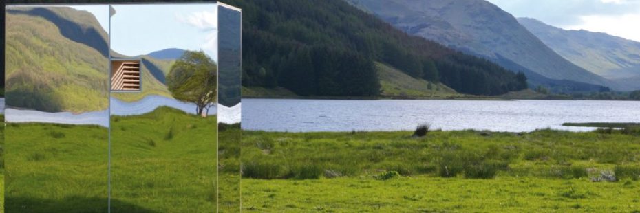 mirrored-art-installation-at-grassy-loch-head-mountain-background