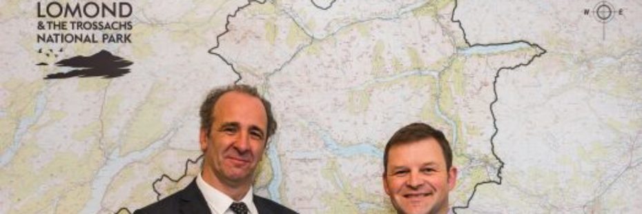 two-smiling-men-standing-in-front-of-national-park-map
