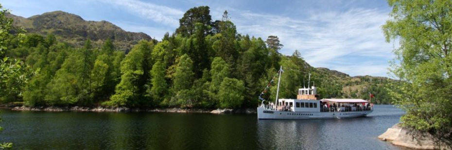 tourist-boat-on-loch-surrounded-by-trees