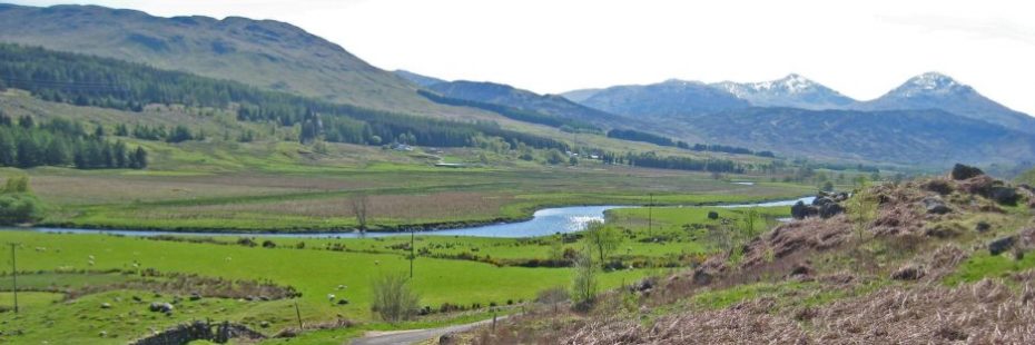 river-through-grassland-surrounded-by-mountains