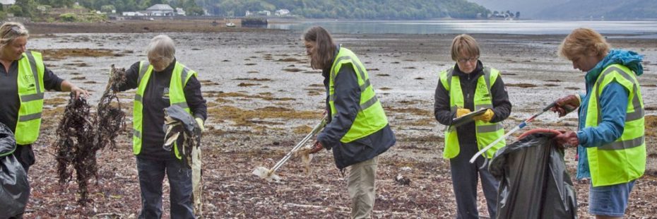 five-people-on-beach-with-litter-pickers-and-bin-bags