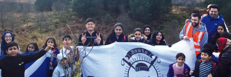 large-group-of-children-and-adults-holding-up-banner-outdoors