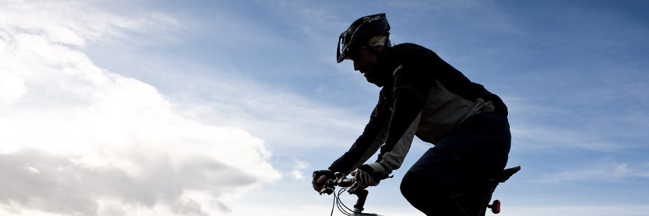 cyclist-with-helmet-on-against-blue-sky