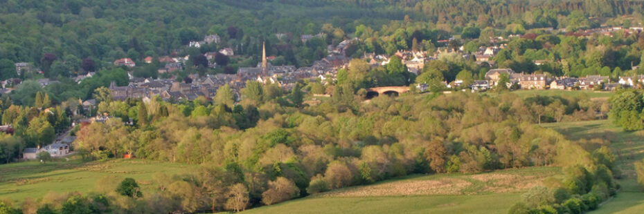 callander-town-seen-from-samsons-stone-surrounded-by-vegetation-church-spire-and-old-bridge-prominent-among-houses