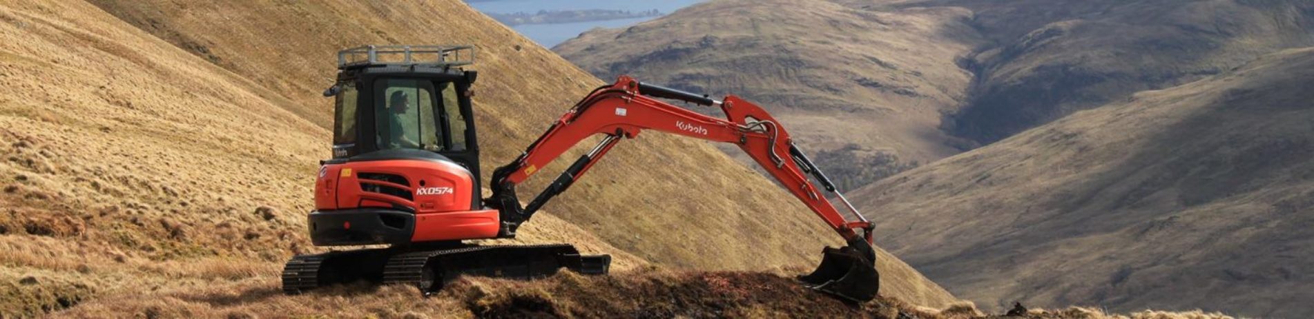 red-excavator-of-peatland-on-brown-hills-with-loch-lomond-just-visible-in-the-background