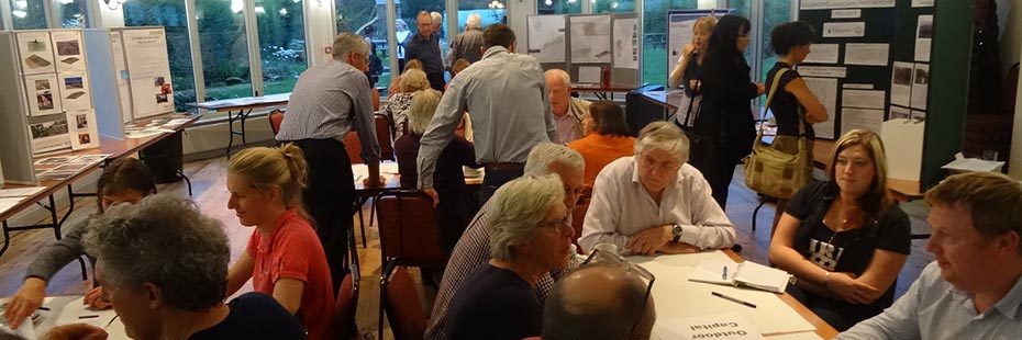 community-action-planning-meeting-in-callander-several-people-at-tables-and-standing-talking
