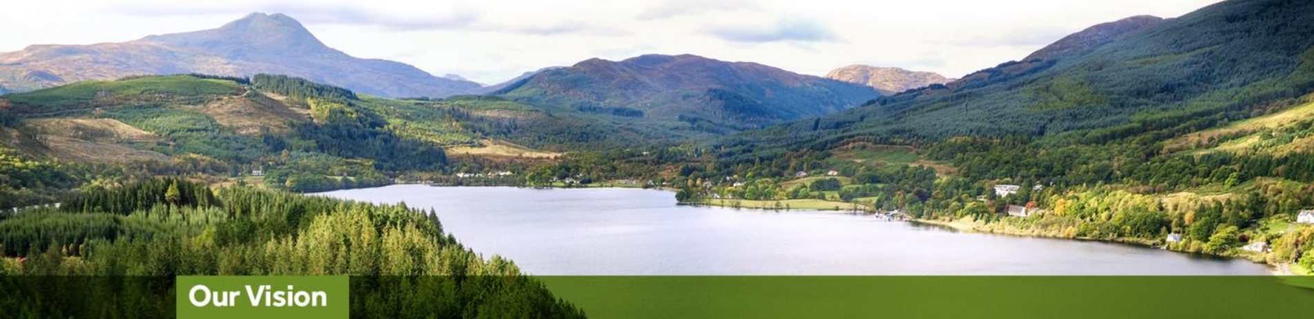 aerial-view-of-loch-ard-surrounded-by-forests-and-with-ben-lomond-towering-above-in-the-distance-with-green-banner-underneath-reading-our-vision