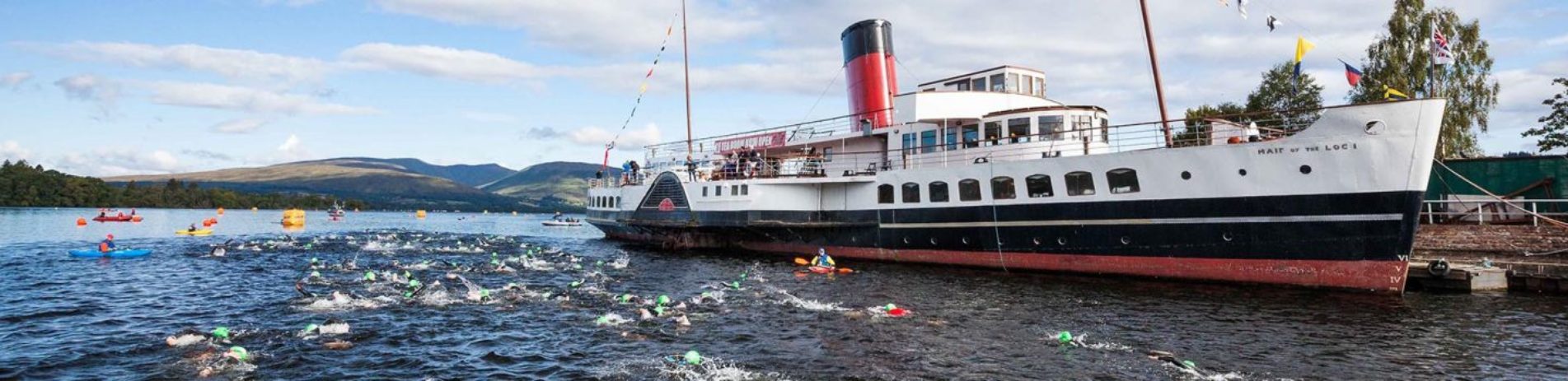 great-scottish-swim-in-loch-lomond-dozens-of-swimmers-wearing-coloured-caps-swim-next-to-maid-of-the-loch-steamship