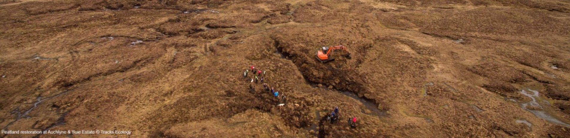 aerial-view-of-peatland-expanse-excavator-and-group-of-people