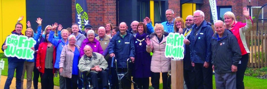 countryside-trust-walk-in-the-park-more-than-two-dozen-middle-aged-and-older-people-smiling-at-camera-and-holding-the-big-fit-walk-banners