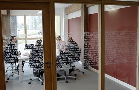 national-park-headquarter-offices-building-room-seen-through-glass-doors-covered-in-gaelic-language-meeting-is-on-with-people-around-table