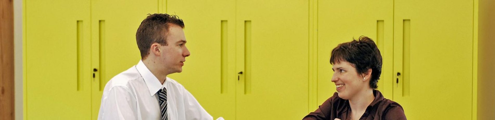 national-park-staff-male-and-female-chatting-to-each-other-with-green-cupboards-behind