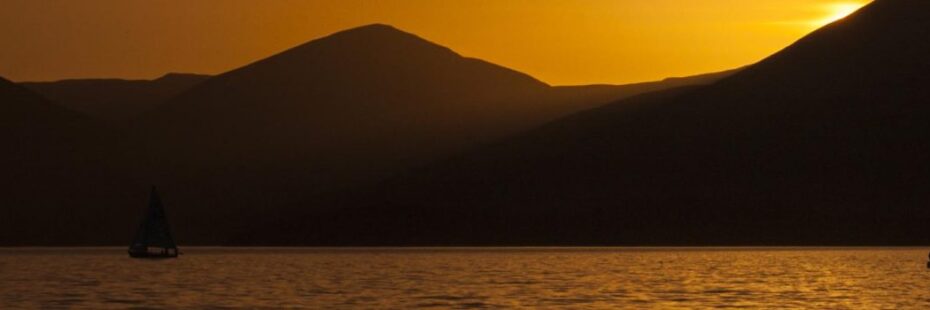 veils-boat-outline-dark-against-setting-sun-light-loch-lomond-and-luss-hills-contour-contrasted-beautiful-incandescent-orange-hues