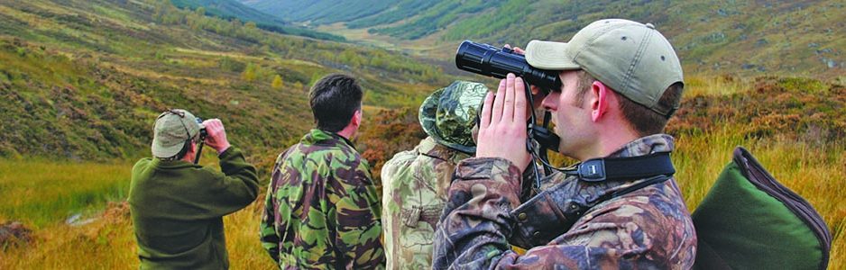deer-stalkers-in-khaki-camouflage-clothes-looking-through-binoculars