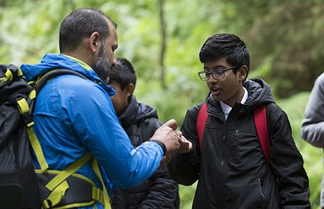 young-volunteers-with-older-man-in-forest-outdoor-learning