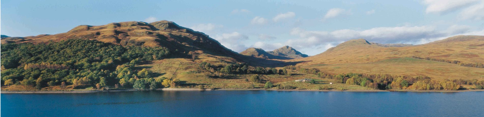 loch-katrine-with-trossachs-hills-behind-great-trossachs-forest-visible-on-left-blue-skies-with-some-clouds