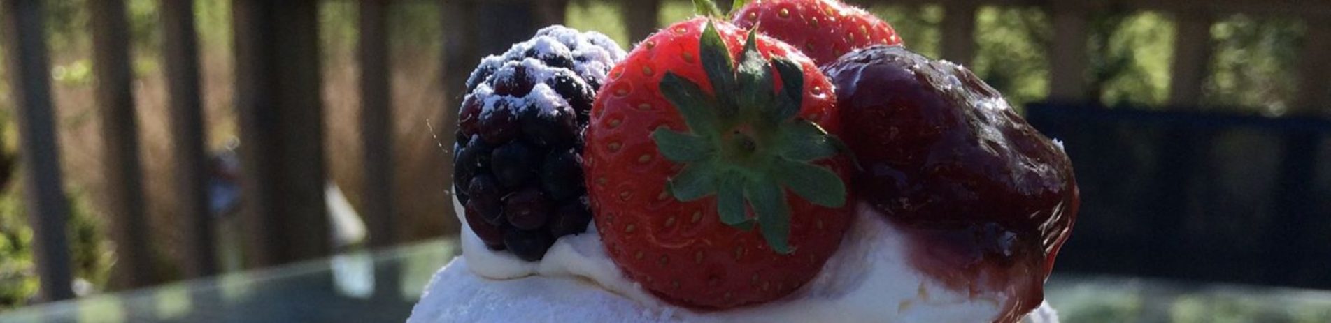 meringue-topped-with-berries-on-table-outside