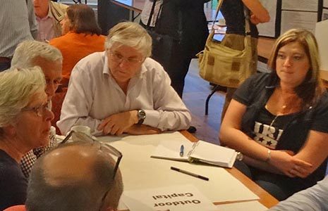 group-of-people-around-table-chatting-and-taking-notes-at-community-event