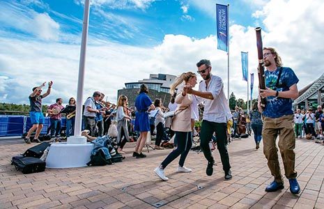 couples-dancing-surrounded-by-people-playing-instruments-and-crowds-cheering-at-lomond-shores-during-balloch-festival-two-thousand-eighteen
