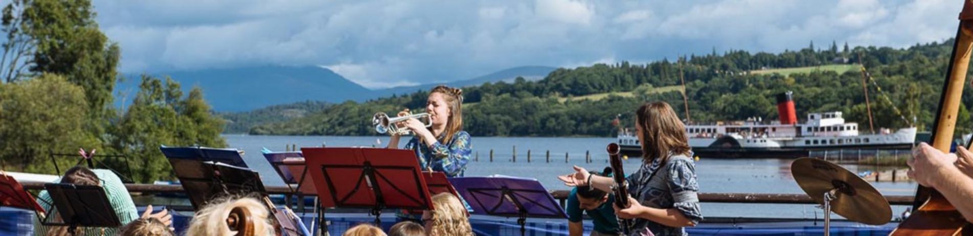 orchestra-playing-at-lomond-shores-balloch-with-loch-lomond-and-maid-of-the-loch-steamship-visible-behind-balloch-festival-two-thousand-eighteen