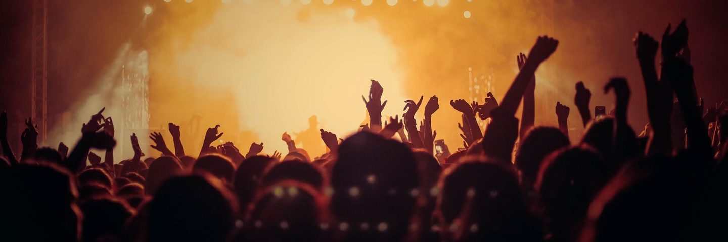 music-festival-atmosphere-orange-lights-and-steam-and-large-crowd-with-hands-up